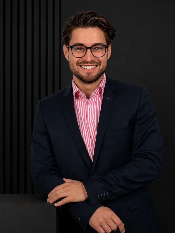 Business-Portrait eines Mannes im dunklen Anzug vor dunklem Hintergrund
