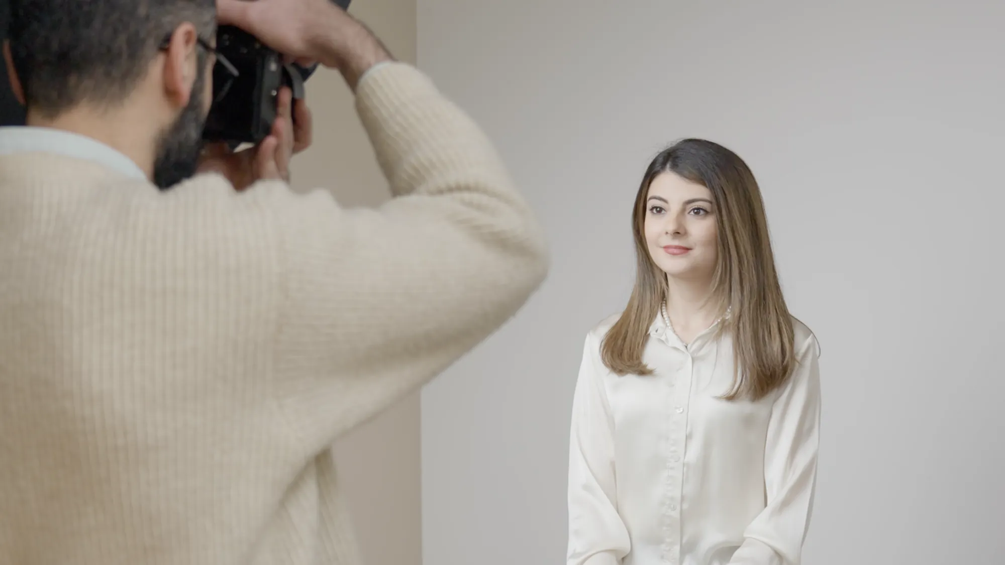 Fotograf fotografiert eine Kundin für ein Passbild im Fotostudio in Jena